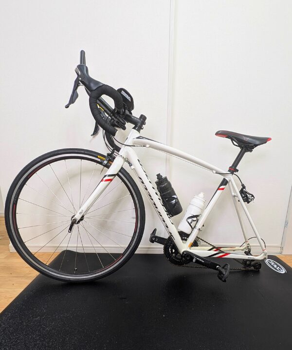 スマートトレーナー NOZA One からロードバイクを取り外して洗車できる様子。自宅トレーニングで汗が溜まっても簡単に丸洗いできる清潔な室内トレ環境。