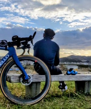 京都のパーソナルトレーナー辻井健次(ツジケン)が、ロードバイクと共にベンチに座り夕暮れの空を見つめる